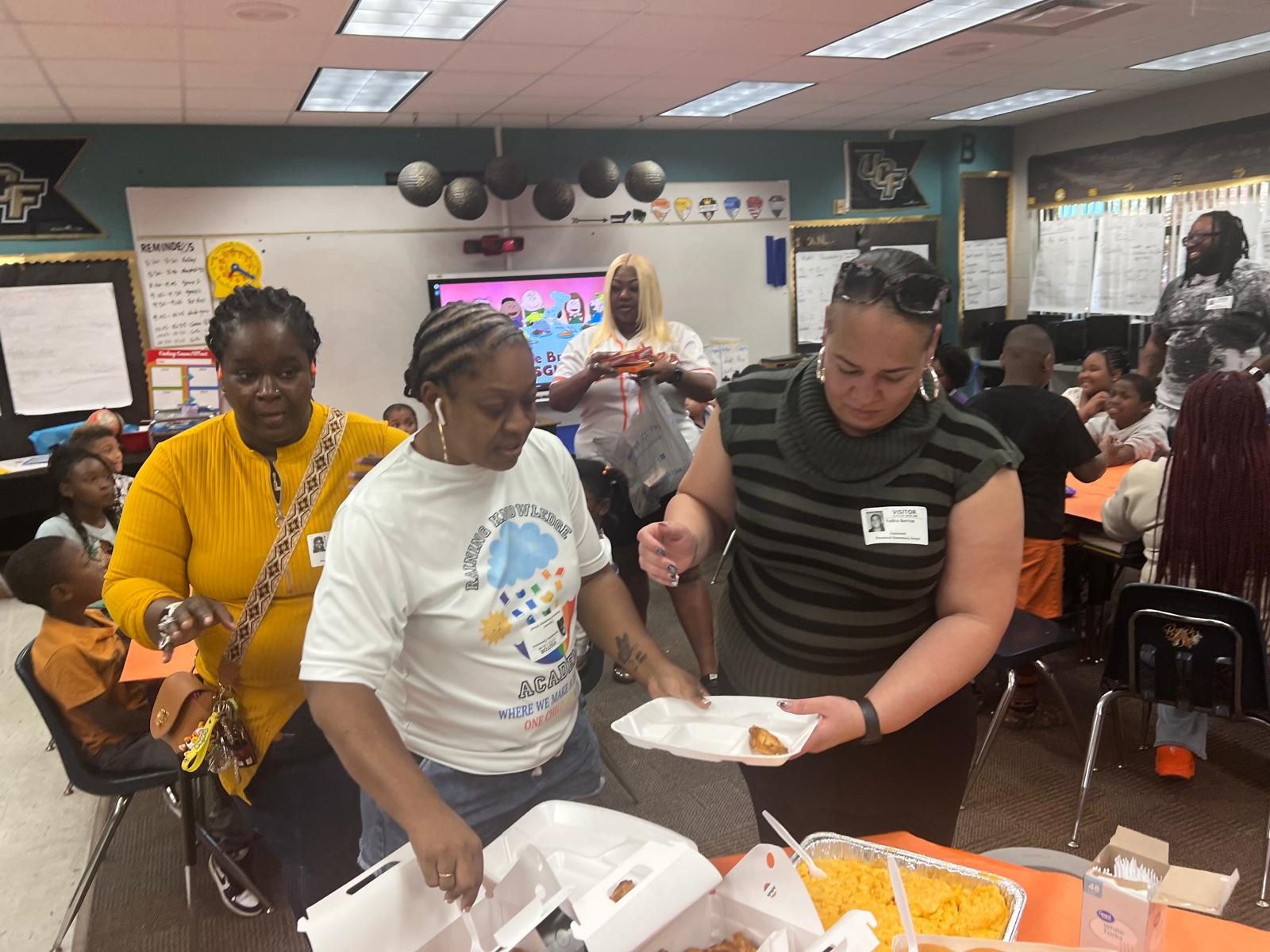 Volunteers serving a classroom meal to students