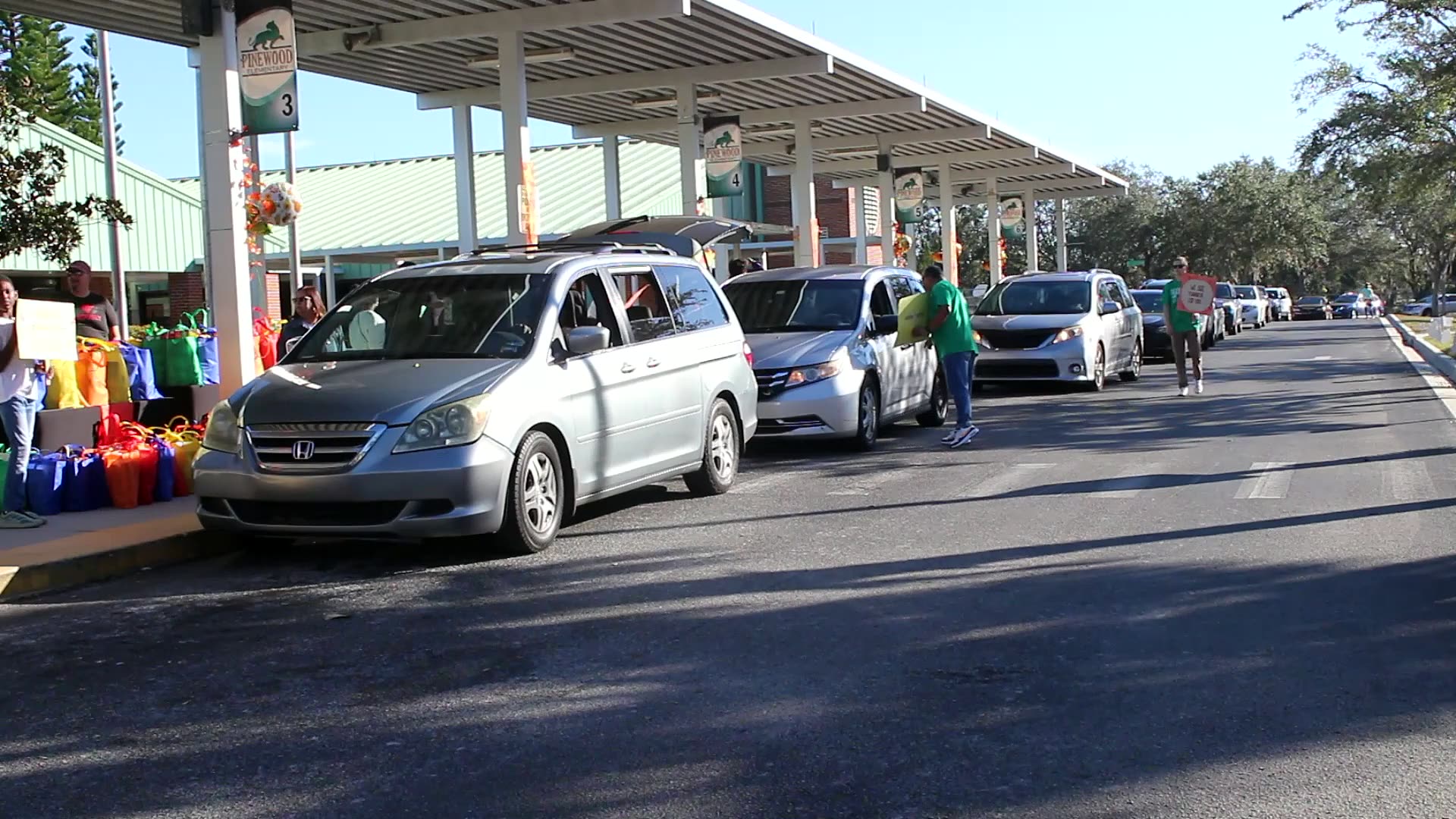 Volunteers loading Thanksgiving groceries into waiting cars